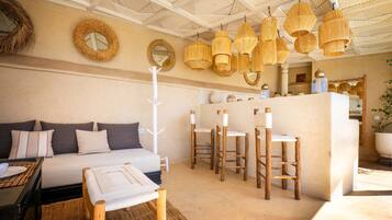 Una habitación con cama, zona de comedor y bar.