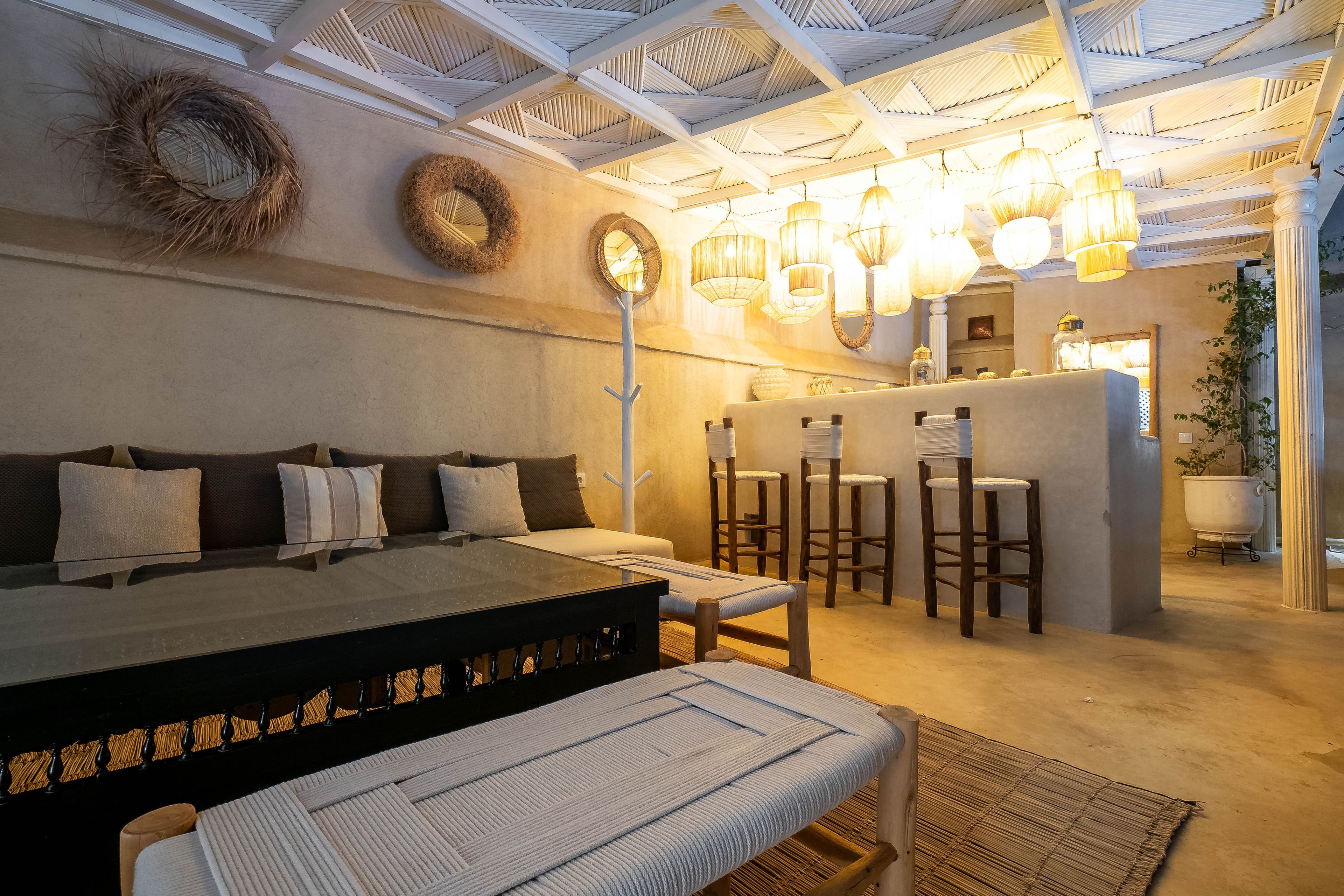 Quarto com cama, uma mesinha e área de bar.