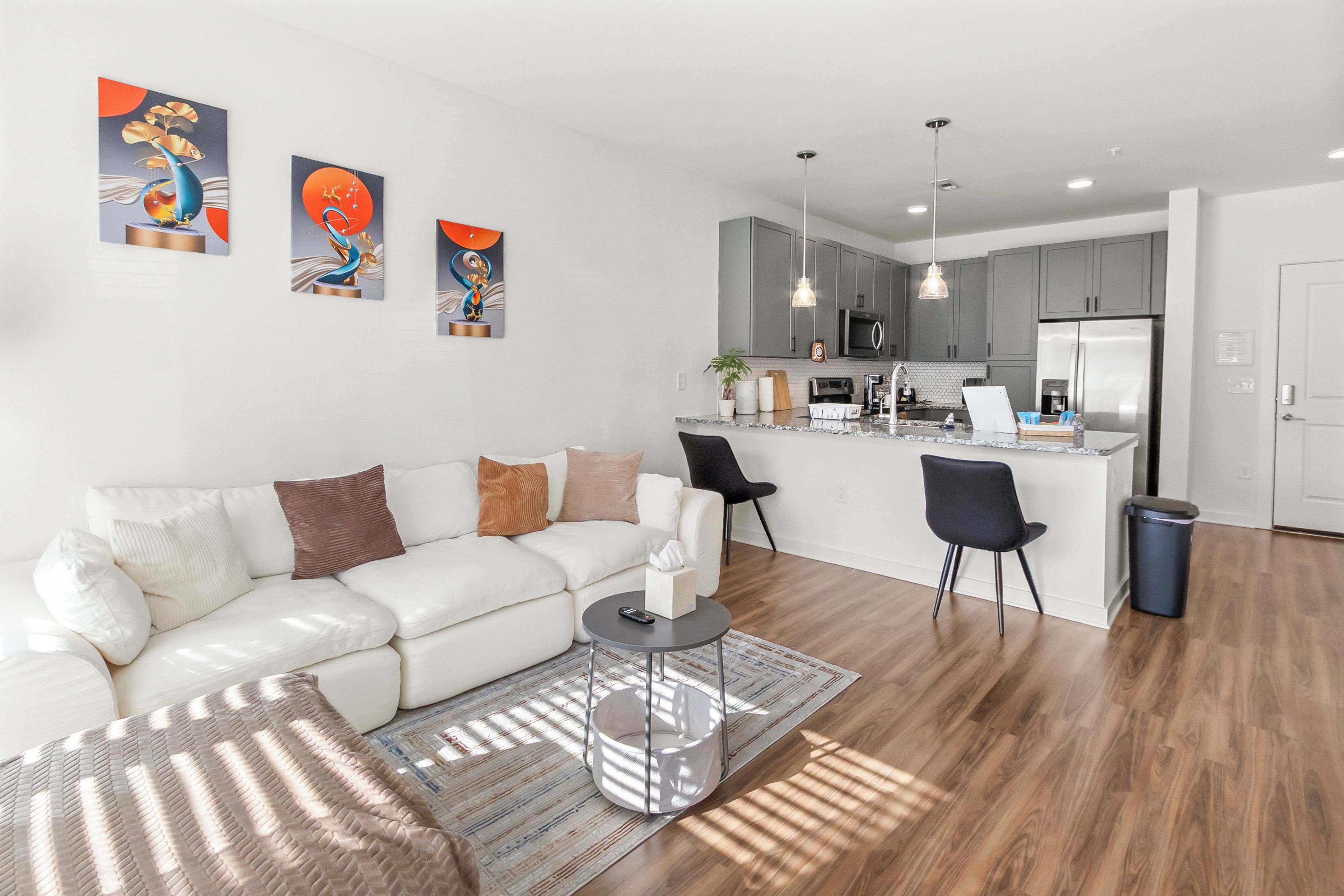A modern apartment with a living area, kitchen, and dining space.