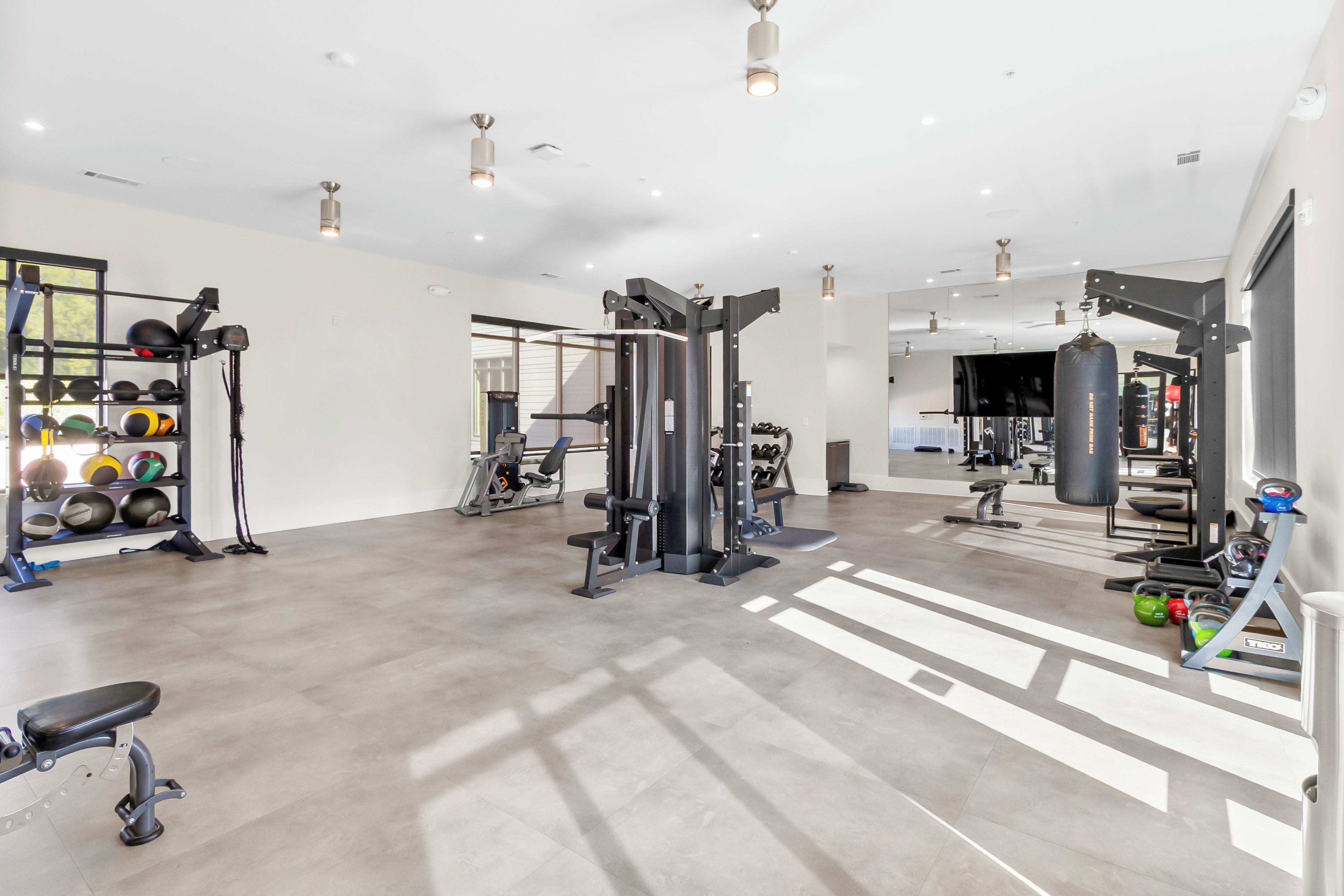 A spacious gym with various exercise equipment, including weight machines and free weights.