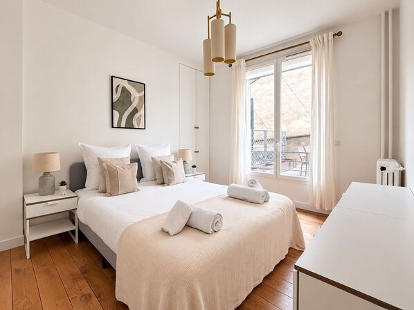 A hotel room with a large bed, bedside tables, a window with curtains, and a view of the outside. - Magnifique Appartement Levallois Perret (Levallois-Perret)