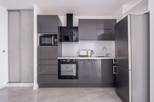 Una cocina moderna con electrodomésticos de acero inoxidable, microondas, horno y refrigerador.