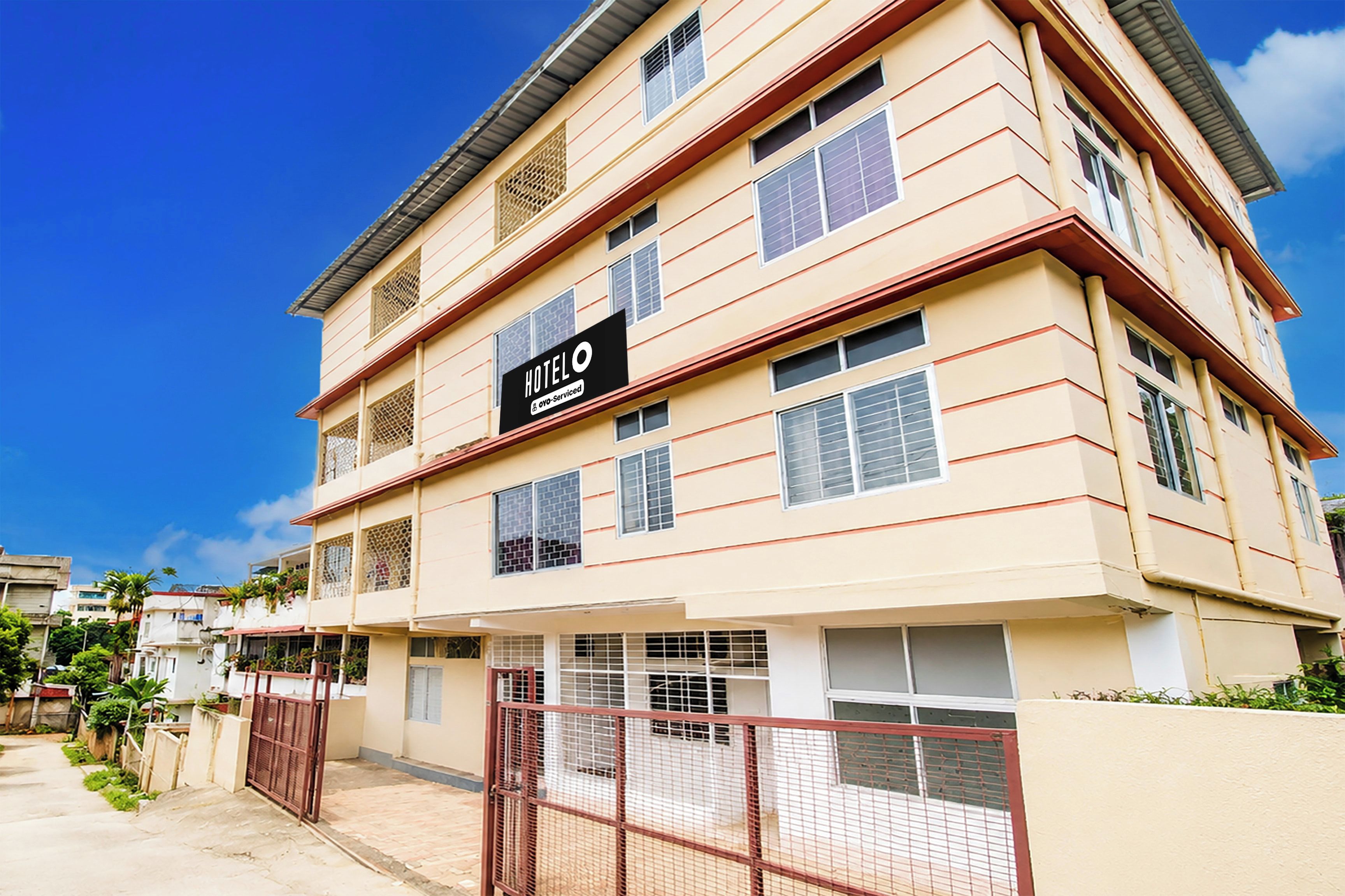 A multi-story hotel building with a sign indicating it is serviced by Agoda.