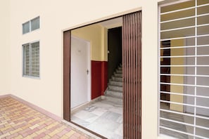 A residential entrance with a sliding door, a staircase, and a tiled floor. - Hotel O City Centre Mall Formerly Stay (Guwahati)