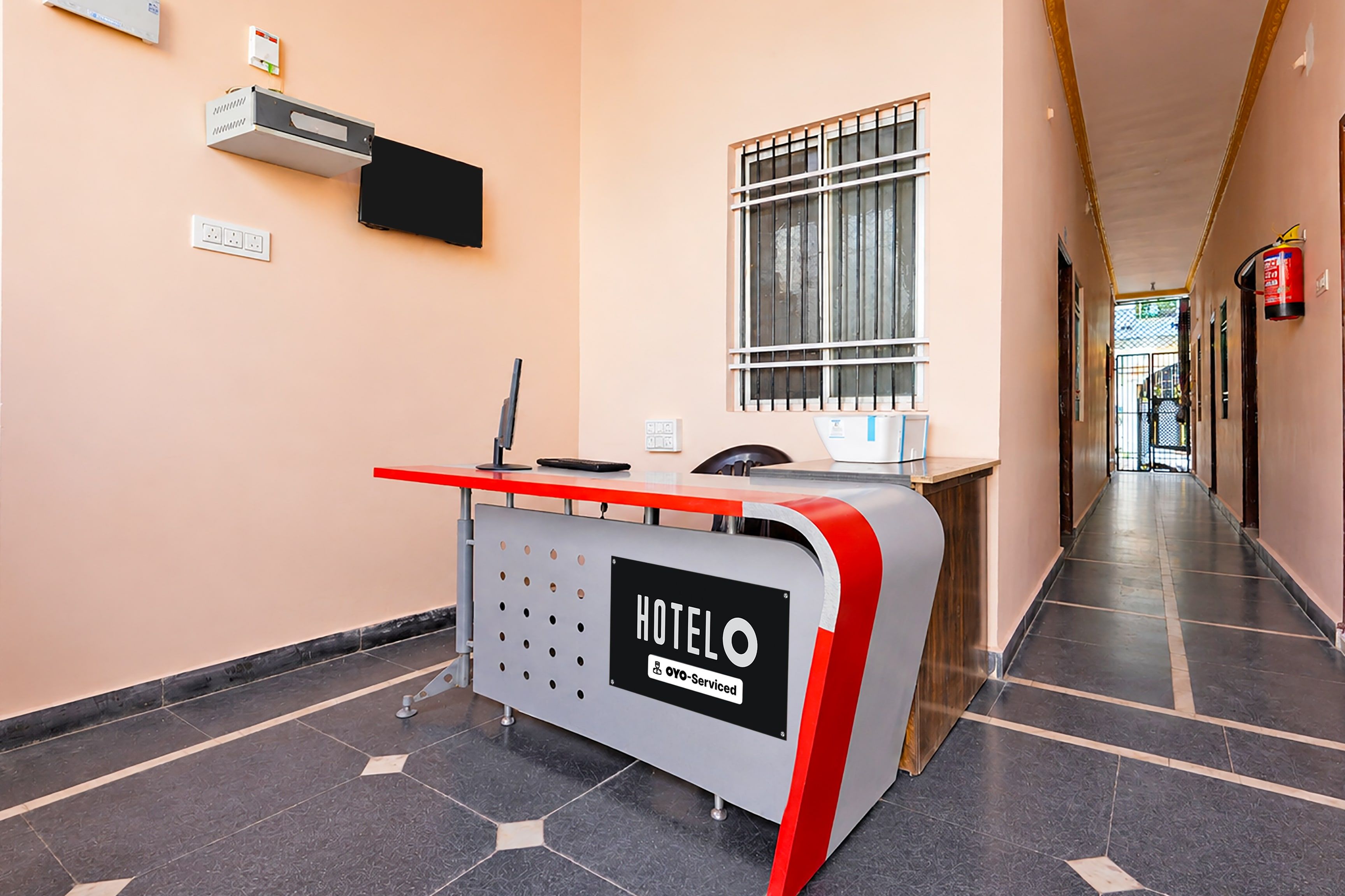 Un comptoir d’accueil d’hôtel avec une enseigne indiquant qu’il s’agit de « HOTELO » et qu’il offre un service « YOYO ».