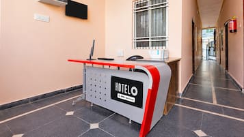 Un comptoir d’accueil d’hôtel avec une enseigne indiquant qu’il s’agit de « HOTELO » et qu’il offre un service « YOYO ».