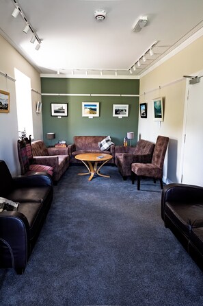 A room with a seating area featuring a brown sofa, a brown armchair, and a wooden coffee table.