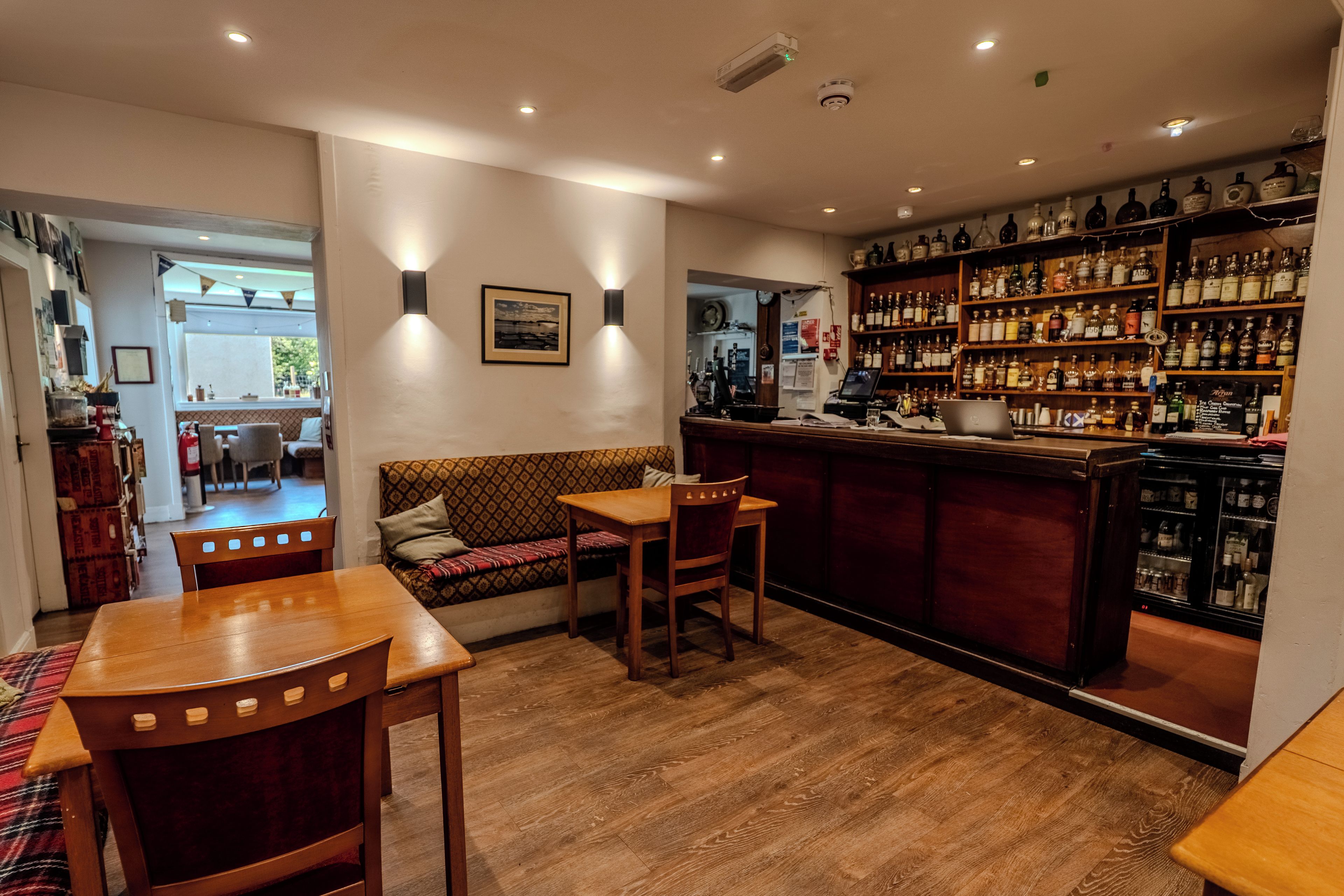 A bar area with wooden furniture and a variety of liquor bottles.