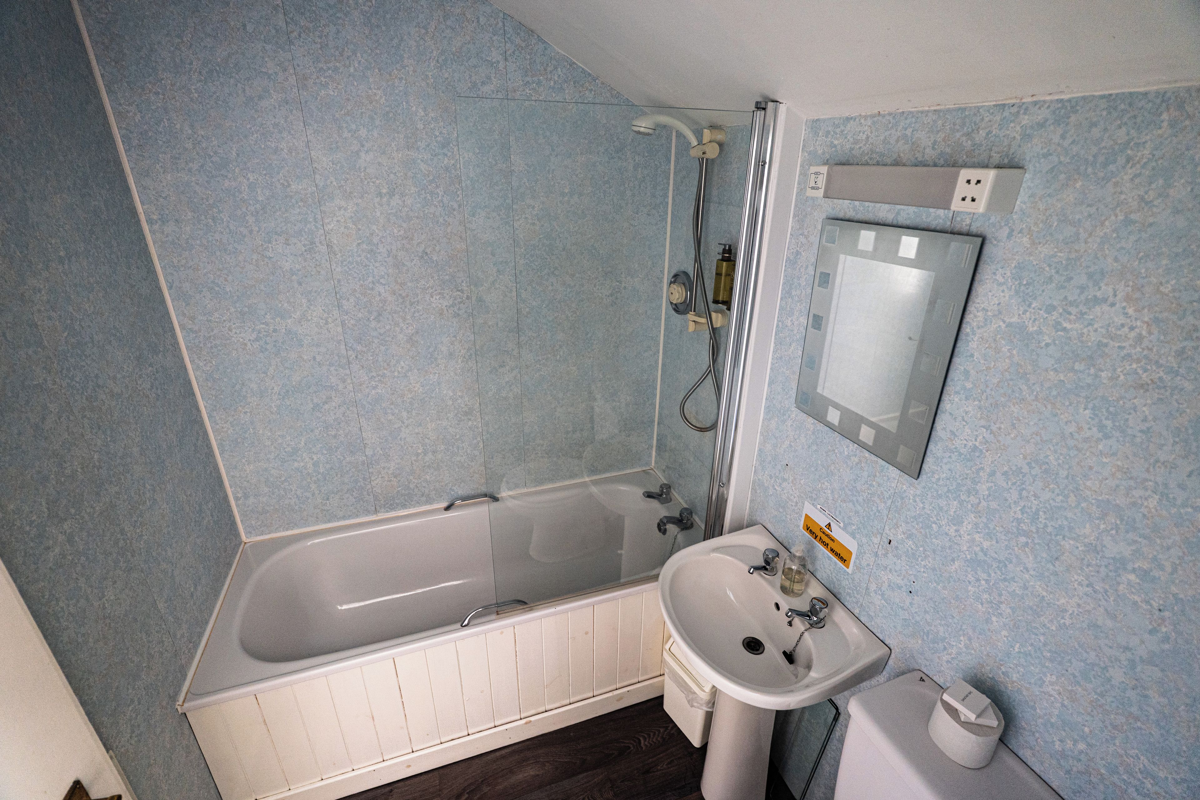 A bathroom with a bathtub, a sink, and a mirror.