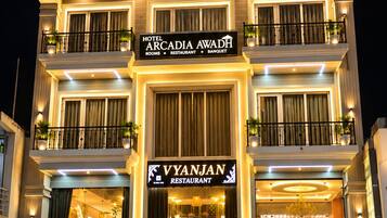 Un hôtel à plusieurs étages qui abrite un restaurant appelé « VYANJAN » au rez-de-chaussée.
