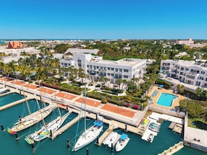 A marina with multiple boats docked, a swimming pool, and buildings with balconies overlooking the water. - A SAFE HARBOUR : 2  BR, 2  BA Condominium in Key West, Sleeps 4 (Key West)