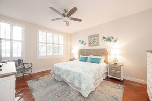 A bedroom with a bed, bedside lamps, a desk, and a chair. - A SAFE HARBOUR : 2  BR, 2  BA Condominium in Key West, Sleeps 4 (Key West)