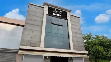 A modern building with a large glass facade and a sign that reads 'Collection Company-Serviced'.