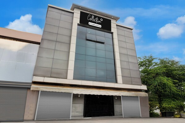 Un edificio moderno con un amplio muro de cristal y un cartel que dice 'Collection Company-Serviced'.