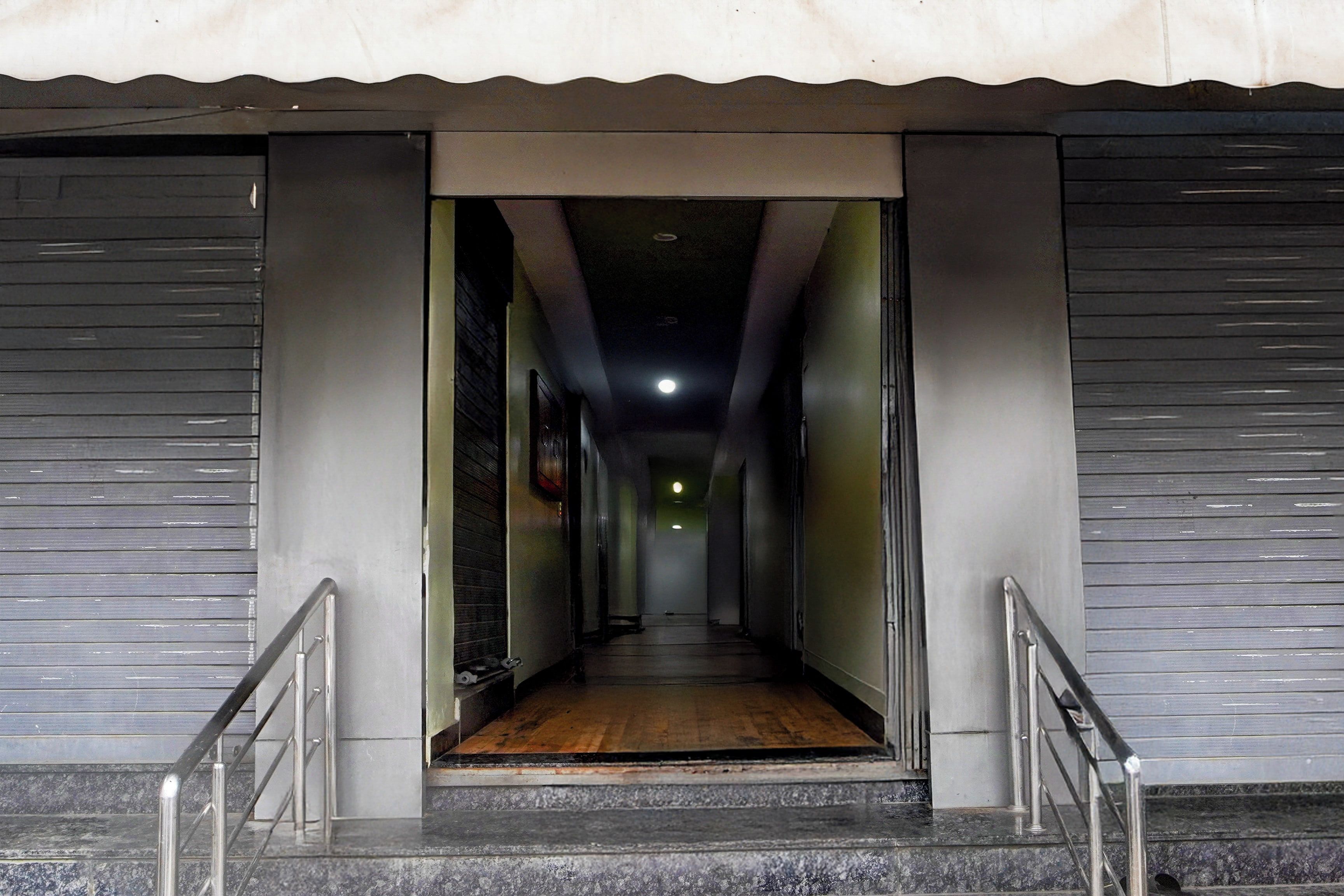 A corridor with a wooden floor leading to a dark interior.