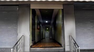 A corridor with a wooden floor leading to a dark interior.