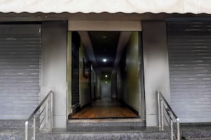 Un pasillo con piso de madera que conduce a un interior oscuro.
