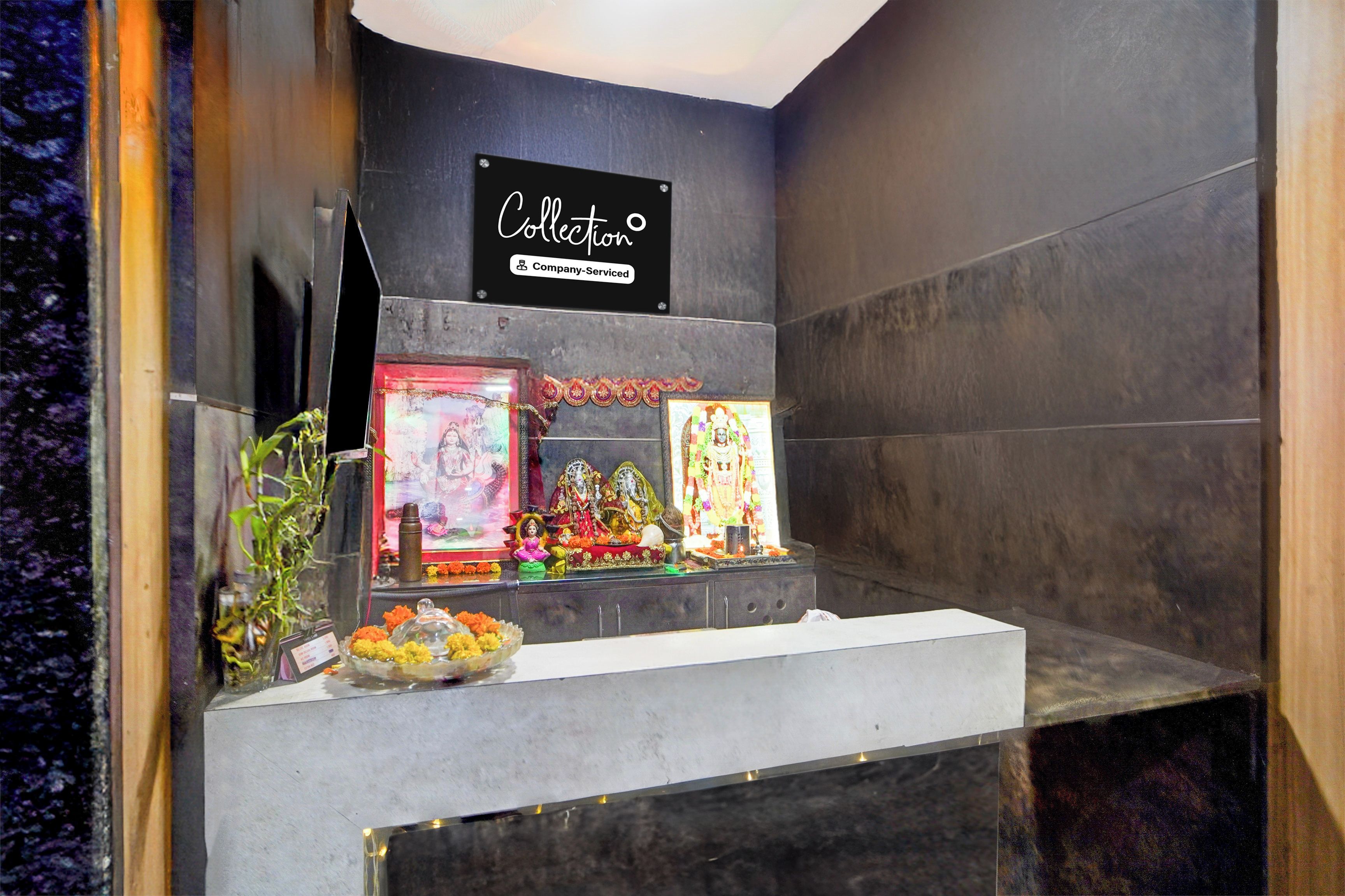 A shrine with religious icons, a sign indicating a collection, and a small altar with offerings.