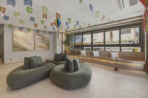Ein modernes Interieur mit Ecksofas, einem großen abstrakten Gemälde und einem Empfangstresen.