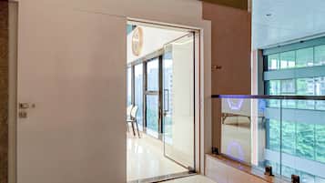 A modern interior with a glass door leading to a balcony with a city view.