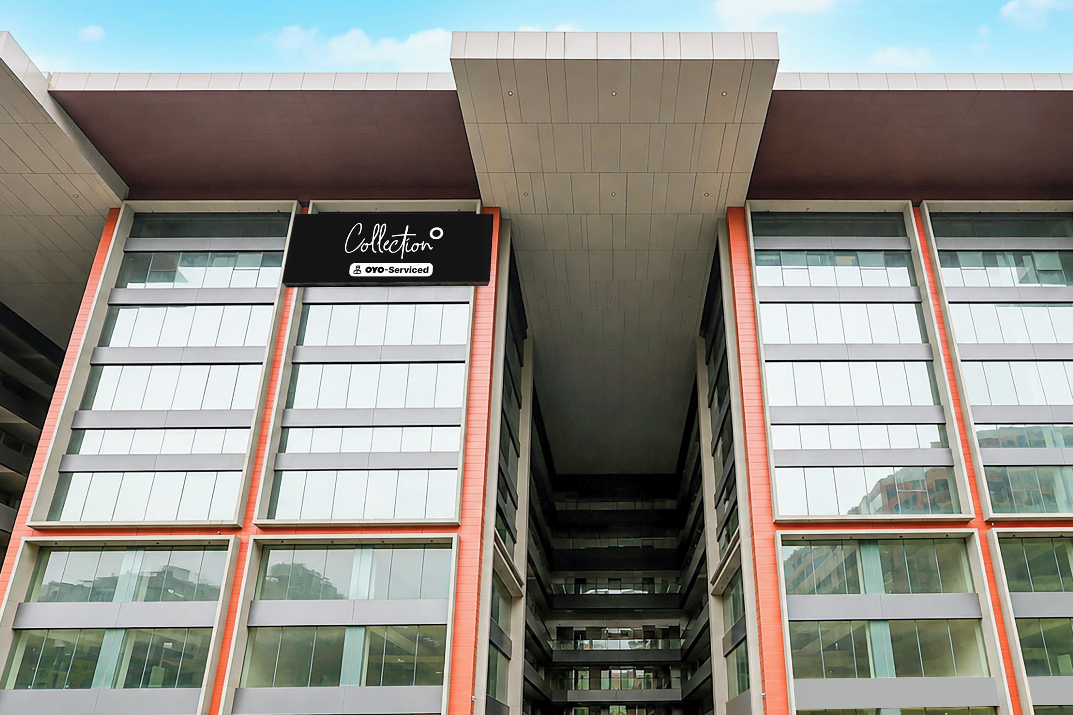 Un edificio moderno con un cartel que indica que cuenta con servicios de OYO.
