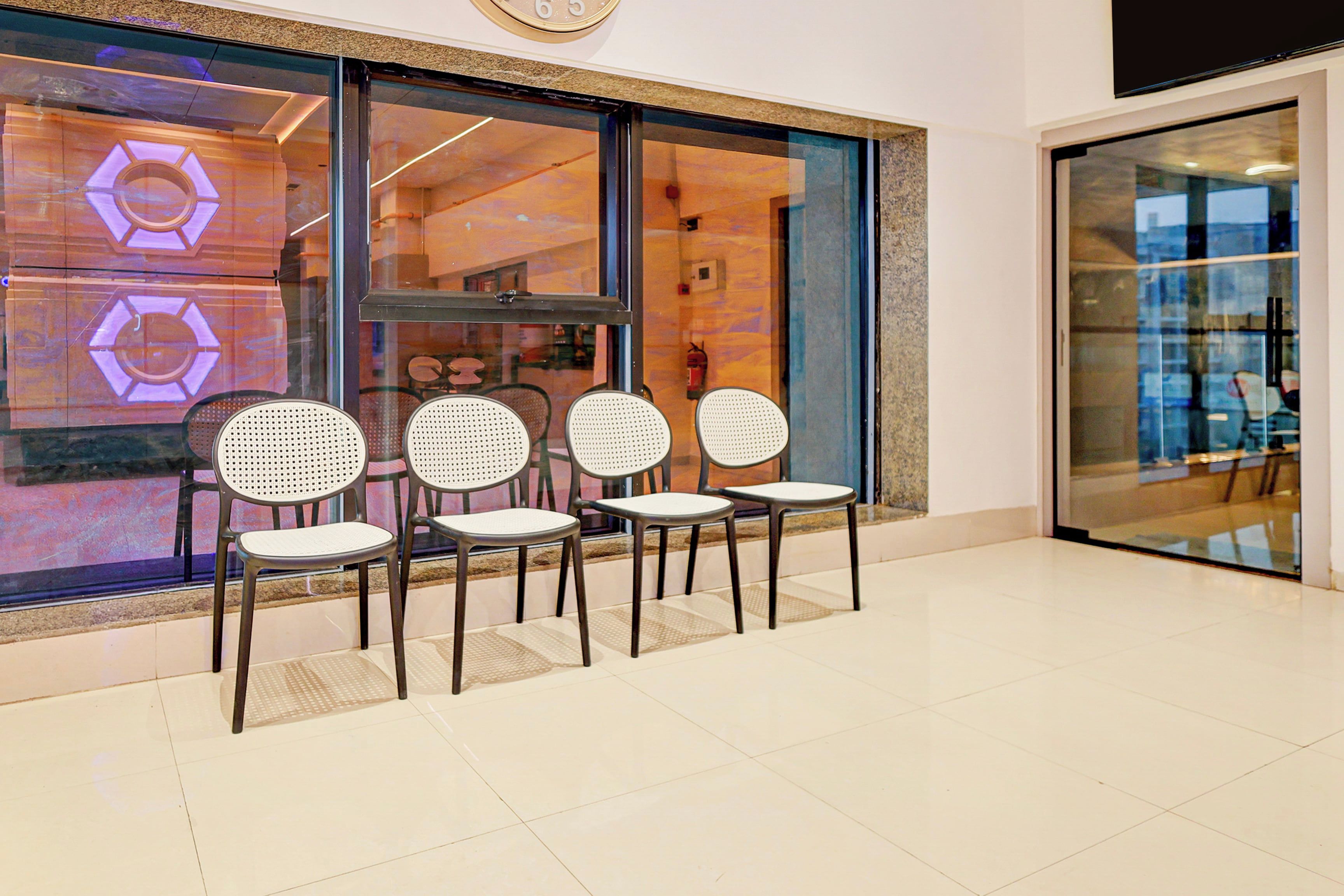 A seating area with four chairs in front of a store window.