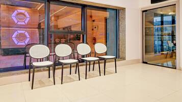 A seating area with four chairs in front of a store window.