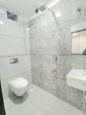 A modern bathroom with a shower, toilet, and sink. - Hotel Jhala Palace (Ujjain)