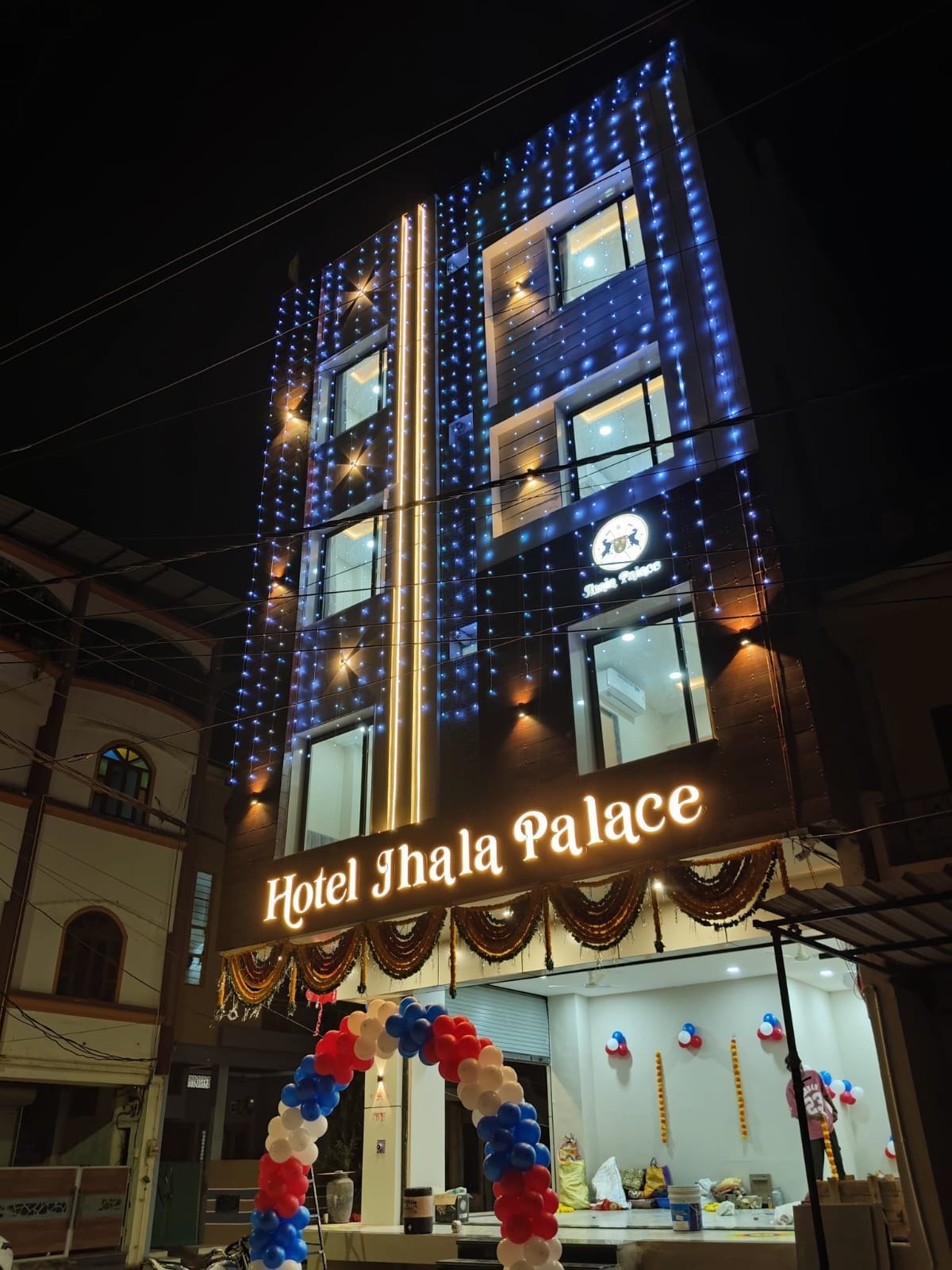 Hotel Jhala Palace with illuminated signage and a decorative archway.