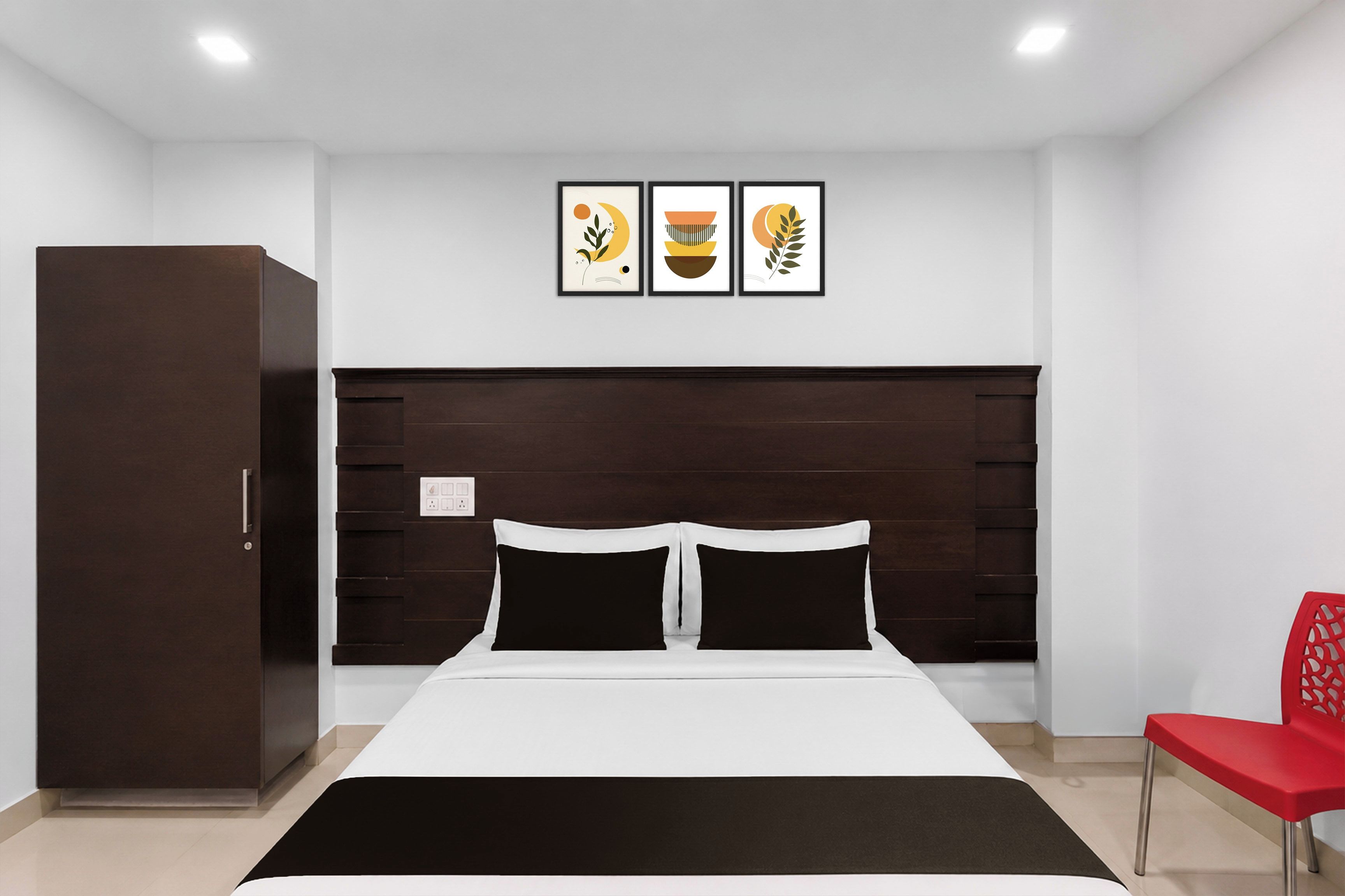 Une chambre à coucher avec un lit, une armoire, un fauteuil rouge et trois œuvres d’art encadrées accrochées au mur.