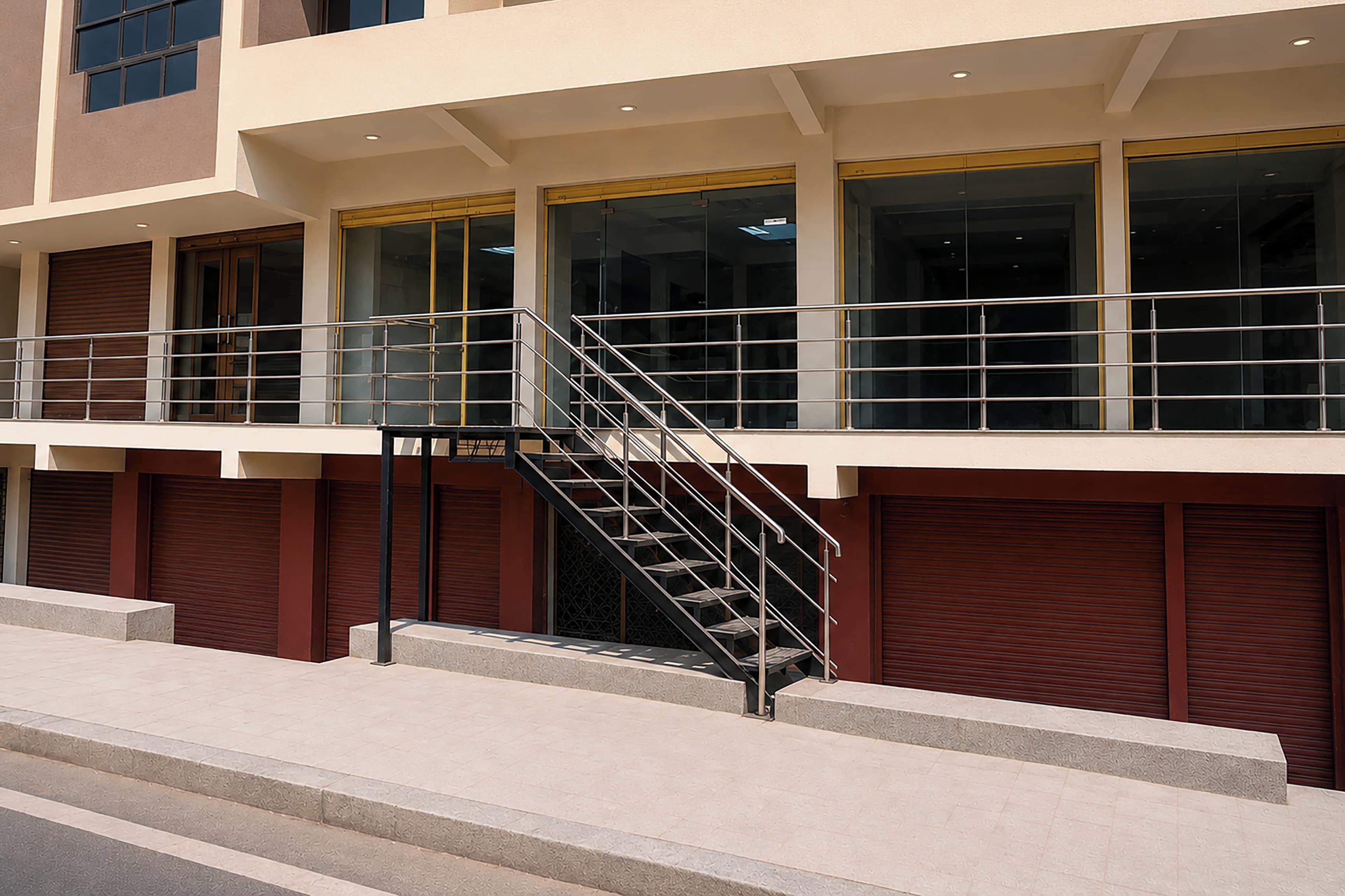A multi-story building with a central staircase, large windows, and a flat roof.