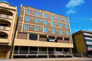 Un edificio de varios pisos con un cartel que indica que cuenta con servicios de OYO.