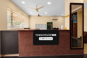 Un comptoir d’accueil avec une enseigne indiquant « TOWNHOUSE OAK » et « YO-Service ».