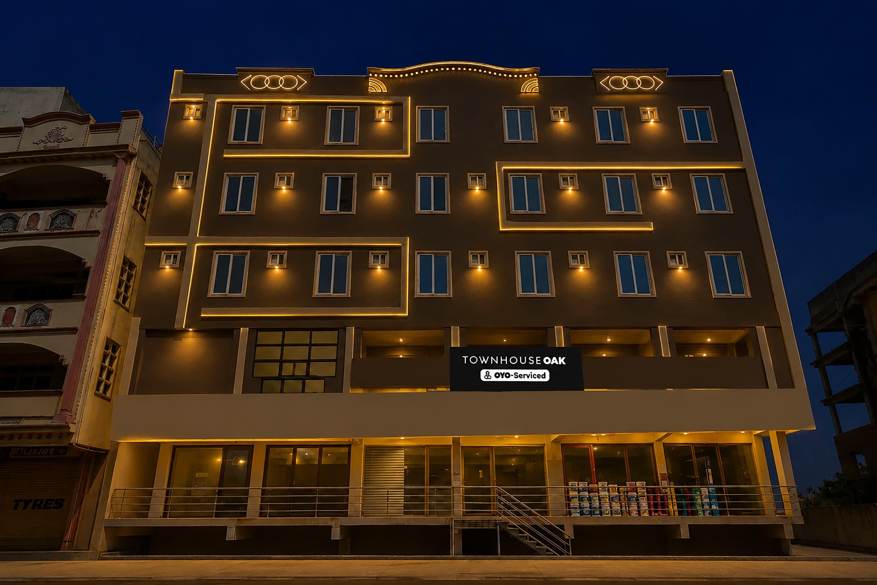 Un edificio de varios pisos con un letrero que dice 'TOWNHOUSE OAK' y 'OYO-Serviced'.