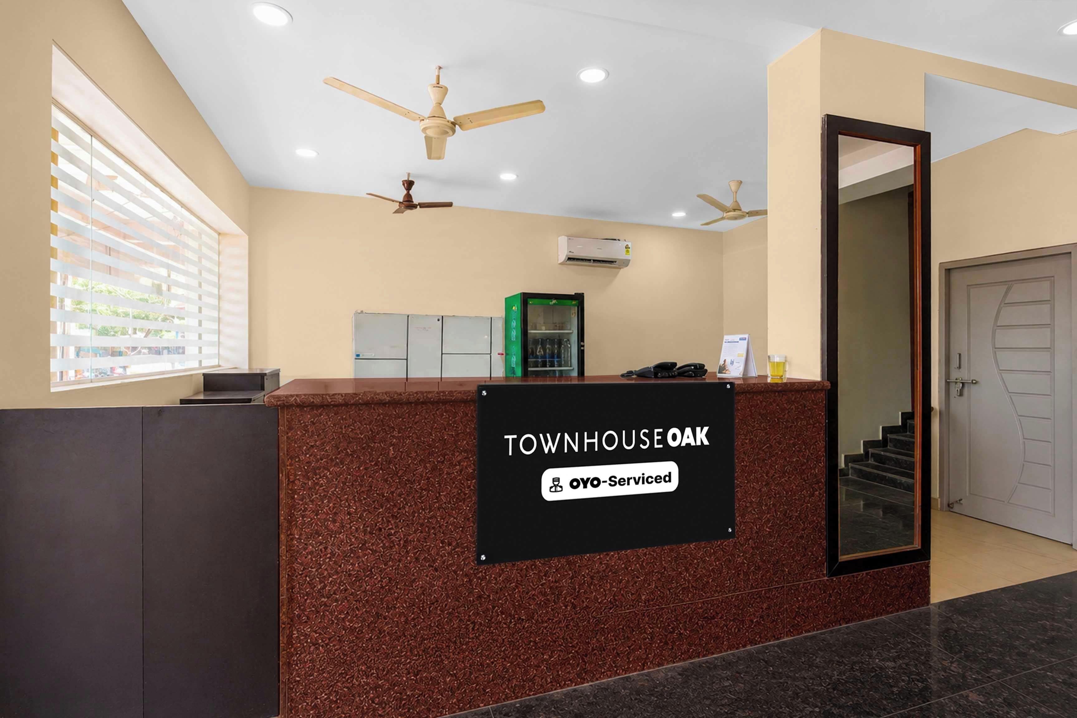 A reception desk with a sign reading 'Townhouse Oak' and 'OYO-Serviced'.