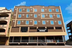 Un edificio de varios pisos con un letrero que indica que cuenta con servicios de OYO.