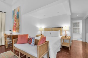 A hotel room with a bed, two bedside tables, a desk, and a chair. - Frangipani Cottage  18+ Adult Only cottage near Duval St (Key West)