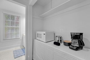 A kitchenette with a microwave, coffee maker, and a container labeled 'COFFEE FILTERS'. - Frangipani Cottage  18+ Adult Only cottage near Duval St (Key West)