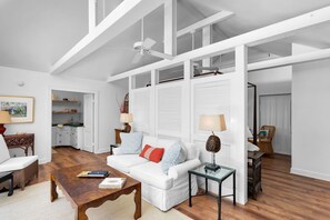 A spacious living room with a white sofa, a wooden coffee table, and a glass-top side table. - Magnolia Manor 18+ Adult Only retreat near Duval Street (Key West)