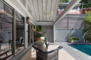 An outdoor patio with a pool, seating area, and a covered section with a ceiling fan. - Magnolia Manor 18+ Adult Only retreat near Duval Street (Key West)