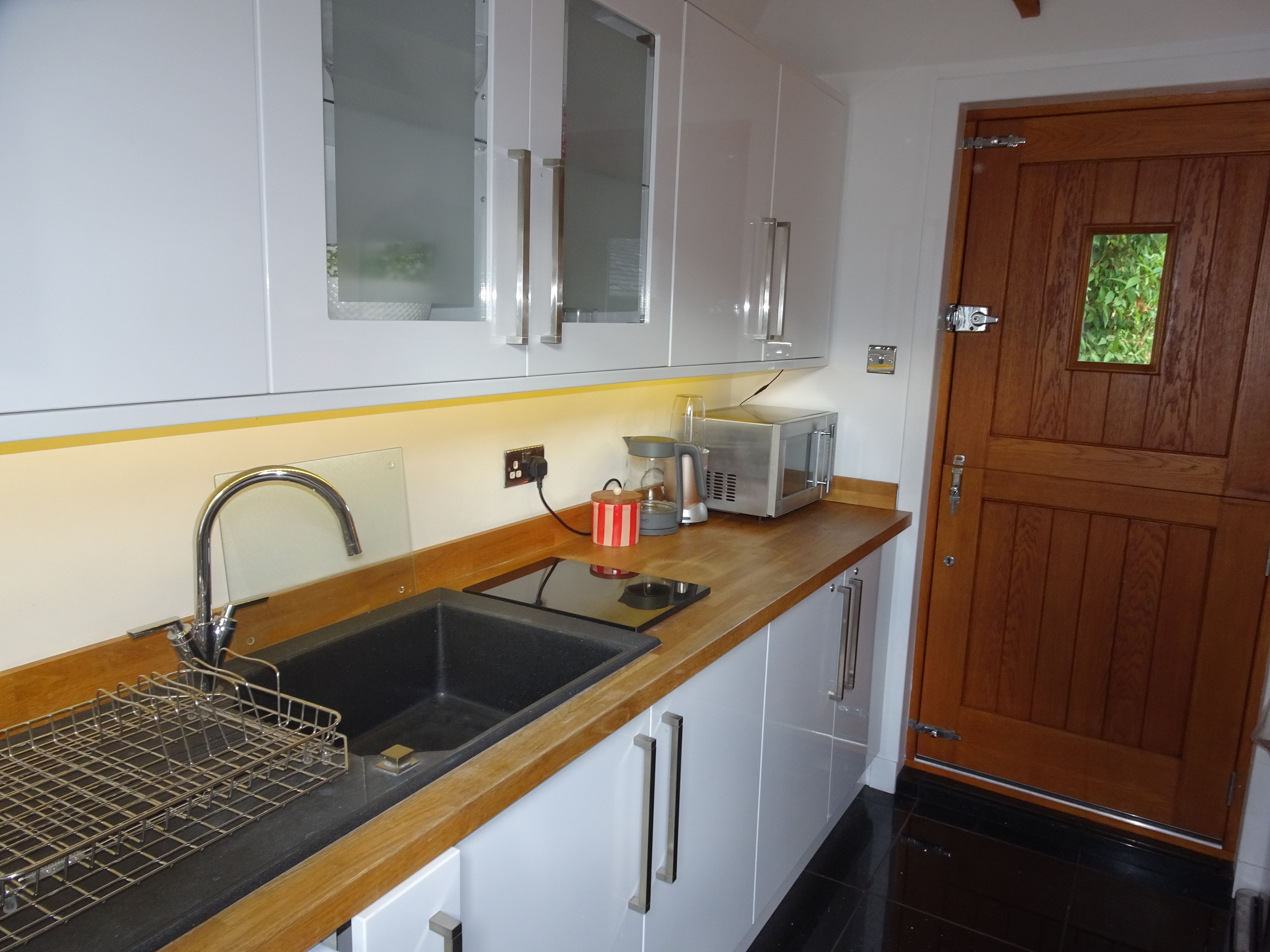 A kitchen with a sink, a coffee maker, and a microwave.