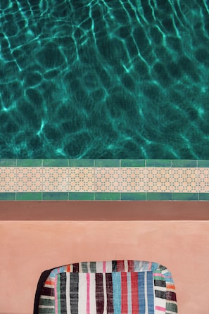 A swimming pool with clear water and a tiled edge. - Terra Verde Oia Suites - Patio Grand Suite with Inner Courtyard View (Oia)