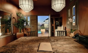 A wooden table with a booklet, a potted plant, and a telephone. - Terra Verde Oia Suites - Patio Grand Suite with Inner Courtyard View (Oia)