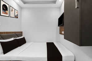 A modern bedroom with a bed, a wardrobe, a flat-screen TV, and framed artwork on the wall. - Hotel O Ripon Street Kolkata (Kolkata)