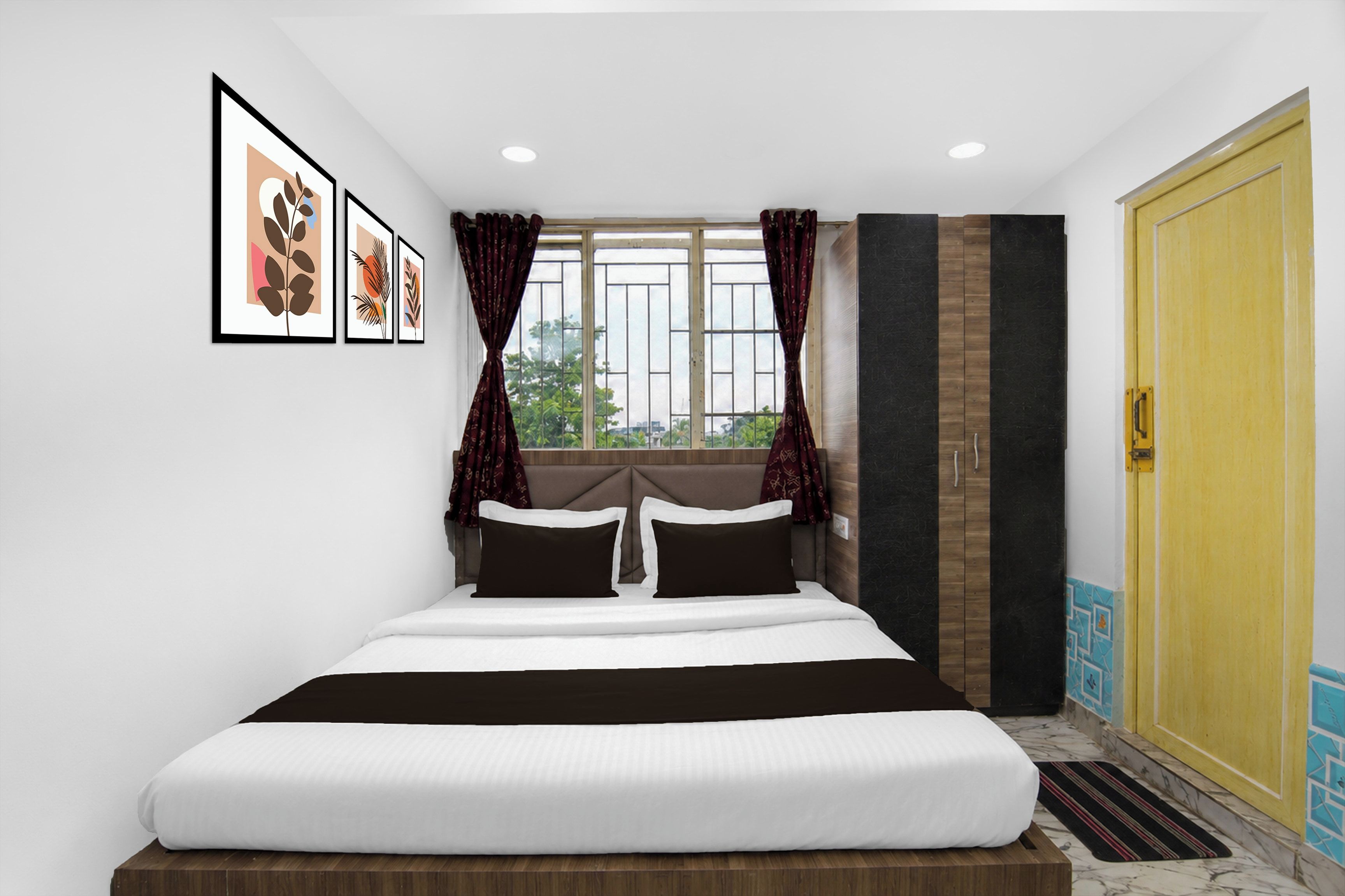 Un dormitorio con cama, ventana con cortinas, armario y cuadros en la pared.