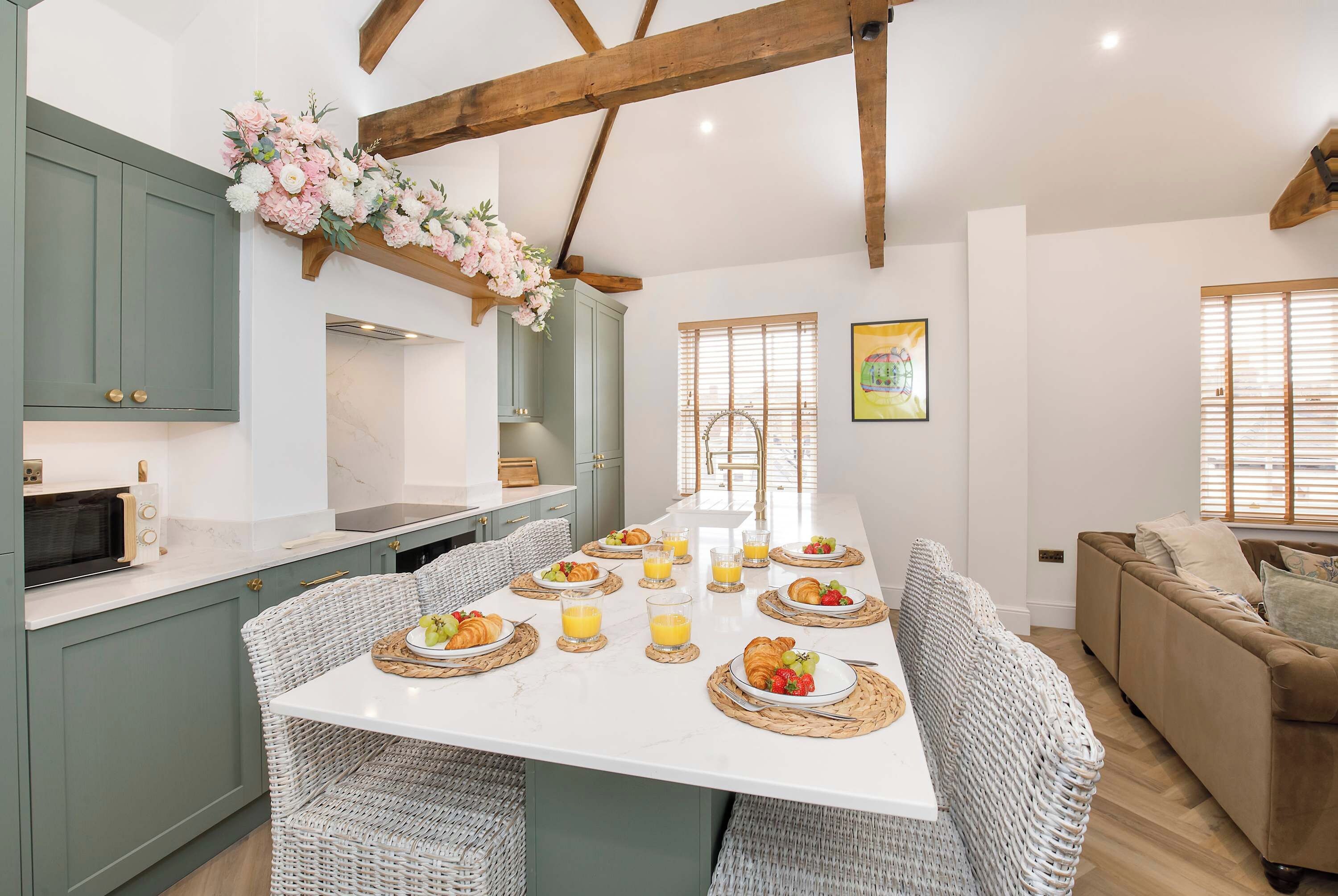 Una cocina moderna con una isla central, mesa de comedor y zona de estar.