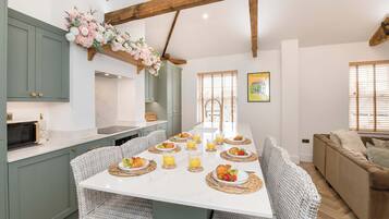 Una cocina moderna con una isla central, mesa de comedor y zona de estar.