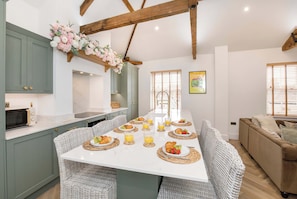 A modern kitchen with a central island, dining table, and seating area. - Ousegate Skyline Retreat, sleeps 6 (York)