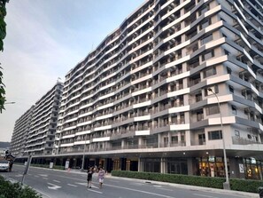 A multi-story hotel with a modern design, featuring balconies on each floor and a covered entrance. - Modern Hotel-Style Condo Near MOA Arena & Mall of Asia and Dedicated Parking (Pasay City)