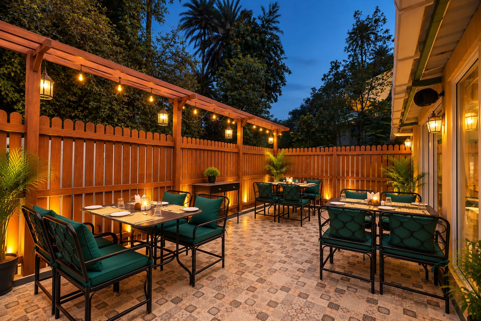 An outdoor patio with tables and chairs, a wooden fence, and string lights.